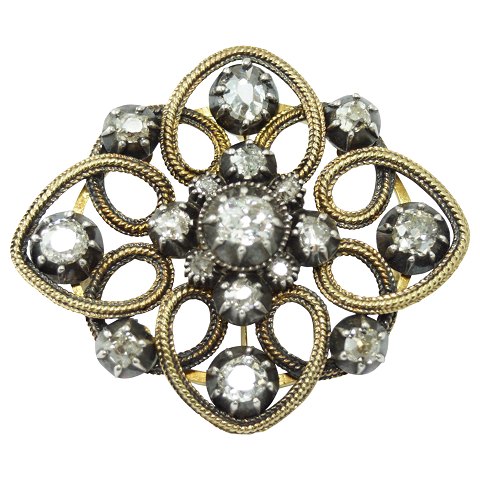 A diamond brooch mounted in 14k gold and white gold