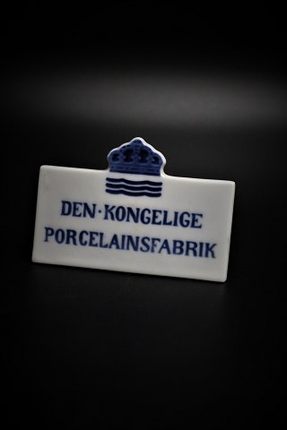 Royal Copenhagen forhandler skilt "Den Kongelige Porcelænsfabrik"
H:6cm. L:9cm.