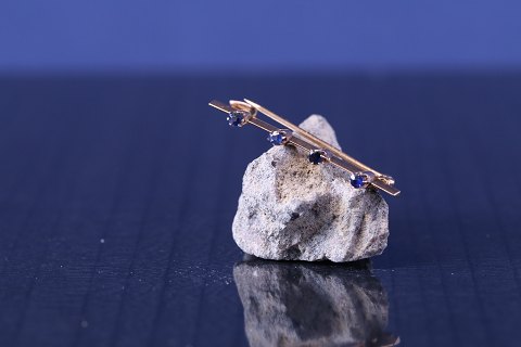 Gold brooch in 14 karat gold, with 4 blue sapphires, stamped 585.