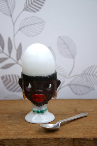 Old egg cup from the 1930s in porcelain with a painted funny face.