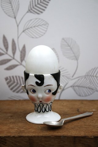 Old egg cup from the 1930s in porcelain with a painted funny face.