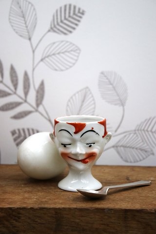 Old egg cup from the 1930s in porcelain with a painted funny face.