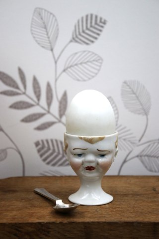 Old egg cup from the 1930s in porcelain with a painted funny face.