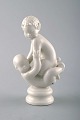 Sjælden Dahl Jensen figur. Blanc de chine. Faun siddende på baby. Modelnummer 
1038.
