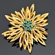 A brooch set with emeralds, mounted in 14k gold