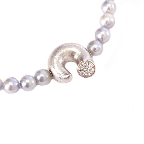 Ole Lynggaard Copenhagen 14kt whitegold clasp "The Optimist" with a Lynggaard 
pearl necklace. Clasp: 18x18mm. Necklace: 42cm